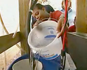 girl pouring water from bucket