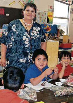 Photo of Santo Domingo artist Cheryl Lucero teaching students to make traditional necklaces.