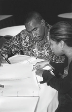 Photo of man and woman reading research at a table.