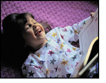 Picture of little girl reading and laughing